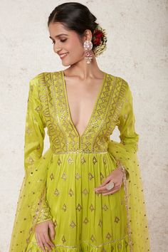 Editor's Note Radiate beauty in this lime green tiered anarkali, adorned with exquisite gota patti motifs and delicate applique work. This stunning ensemble comes complete with a matching churidar and dupatta, adding a touch of grace and elegance to your look. Embrace the allure of traditional craftsmanship and be the center of attention at any event or celebration. Fabric: Tussar silk, net tikki Color: Green Component: Anarkali, churidar and dupatta Occasion: Festive and wedding guest Note: Pro Green Maxi Length Traditional Wear With Cutdana, Green Cutdana Anarkali Set For Navratri, Festive Green Palazzo Set With Dupatta, Traditional Green Floor-length Palazzo Set, Green Chanderi Anarkali Set With Cutdana, Green Chanderi Anarkali Set With Cutdana Details, Anarkali Style Floor-length Pista Green Palazzo Set, Green Floor-length Kurta With Cutdana Detail, Green Anarkali Set For Navratri Designer Wear