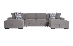 a gray sectional couch with pillows on it