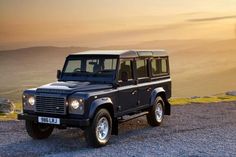 a black land rover parked on top of a hill