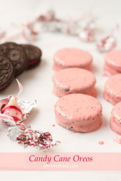 candy cane oreos are arranged on a table with other candies and chocolate cookies