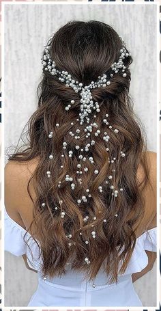 the back of a woman's head with flowers in her hair and pearls on it