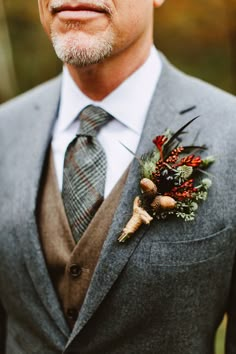 a man wearing a suit and tie with a boutonniere