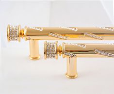 two gold - plated rollers with diamonds on them are sitting next to each other