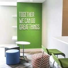 an office with green and white walls, two chairs and a round table in the foreground