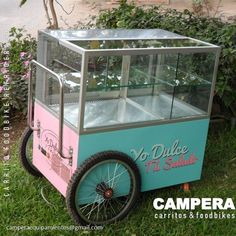 a pink and blue ice cream cart sitting in the grass