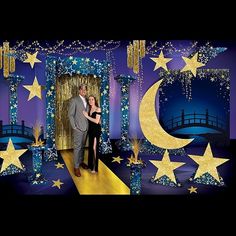 a man and woman standing in front of a backdrop with stars