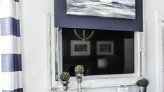 an old window frame is painted white and has blue stripes on the outside, along with potted plants