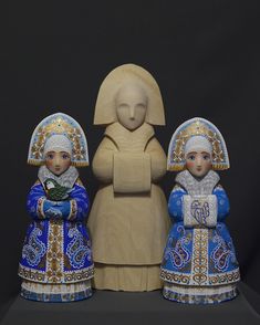 two figurines are standing next to each other in blue and gold dresses, one is holding a bird