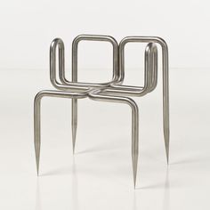 three metal objects sitting on top of each other in the middle of a white floor