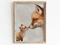 a painting of two foxes kissing each other in front of a white wall with a gold frame