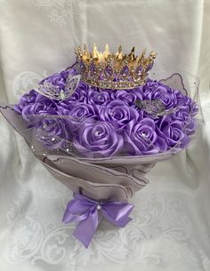 a bouquet of purple roses with a crown on top