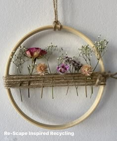 an embroidery hoop with flowers hanging from it