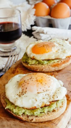 two eggs and avocado on toasted bread with red wine in the background