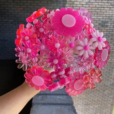 a hand holding a bouquet of pink flowers