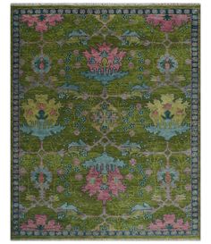 a green rug with pink and blue flowers on the bottom, in front of a white background