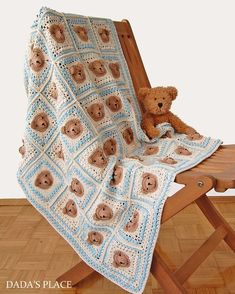 a teddy bear sitting on top of a wooden chair next to a crocheted blanket