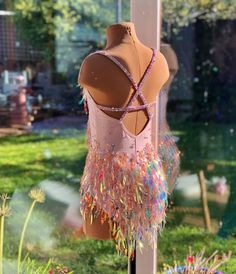 a mannequin wearing a pink leotard with multicolored sequins