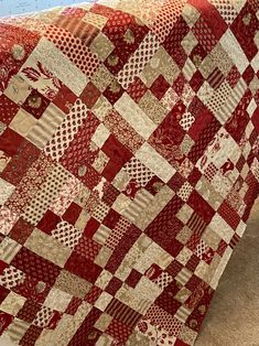 a large red and white quilt on the floor