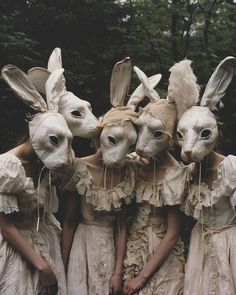 four people wearing bunny ears are standing in front of each other with rabbits on their heads