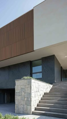 an exterior view of a modern building with stone steps leading up to the front door