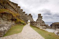 a stone path leading to an old castle by the ocean