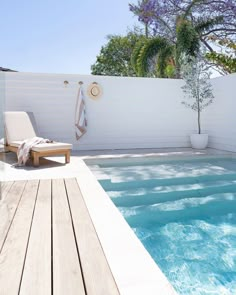 an outdoor swimming pool with lounge chairs next to it