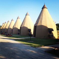 a row of brown buildings sitting next to each other on top of a grass covered field