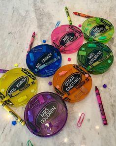 several different colored pencils and markers on a marble counter top with crayons