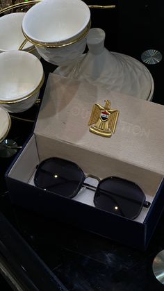 a pair of black sunglasses sitting on top of a table next to plates and bowls