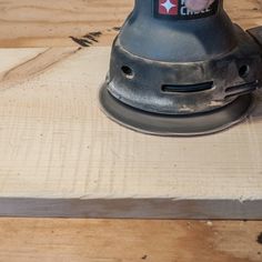 an angle grinder is sitting on top of a piece of wood that has been sanded