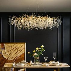 a dining room table and chairs with flowers in vases on the table next to it