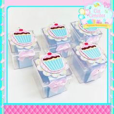 four small cupcakes in clear boxes with bows