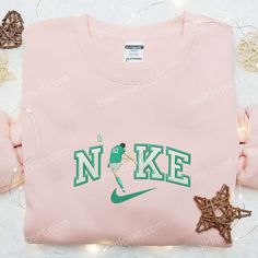 a pink nike shirt with the letter n k e on it and star decorations around it