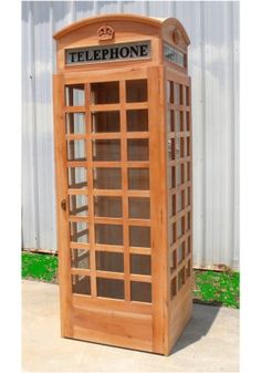 a wooden phone booth sitting on top of a sidewalk