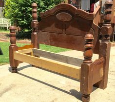 a wooden bed frame sitting on top of a sidewalk