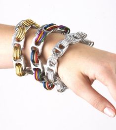 a woman's hand holding several different colored bracelets