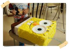 a cake that looks like a spongebob with googly eyes on it is being held by a child