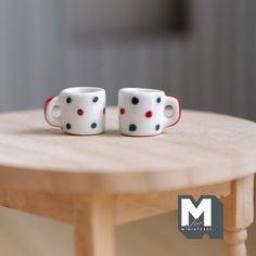 two coffee cups sitting on top of a wooden table