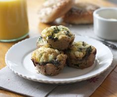 three muffins on a white plate next to a glass of orange juice