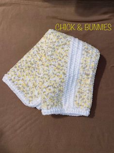 a crocheted blanket with the words chick and bunnies written on it in yellow