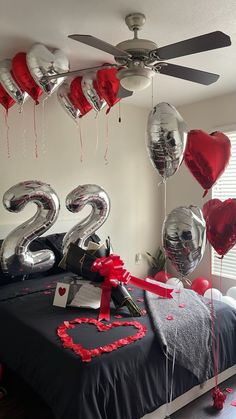 a bedroom decorated for valentine's day with balloons and decorations