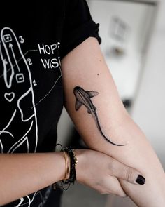 a woman's arm with a whale tattoo on it