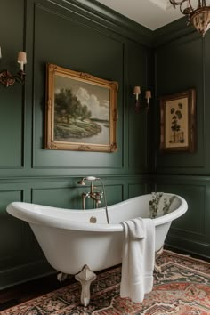 a bathroom with green walls and an antique bathtub