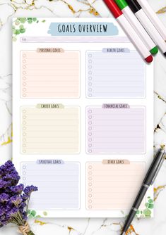 a printable goal sheet with flowers and markers on it, next to some pens