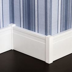 the corner of a bed with blue and white striped sheets