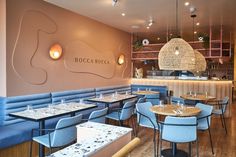 the interior of a restaurant with blue chairs and tables