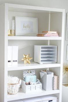 a white book shelf filled with lots of books and other items on top of it