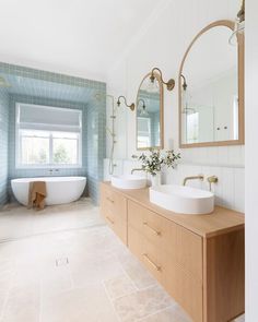 a large bathroom with two sinks and a bathtub in it's center area