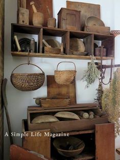 an old fashioned kitchen with wooden shelves and baskets on the top shelf, along with other items