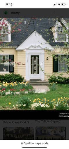 an image of a yellow caped house with flowers in the front and side yard